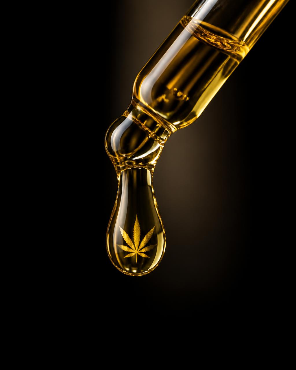 Golden cannabis oil suspended in a glass dropper